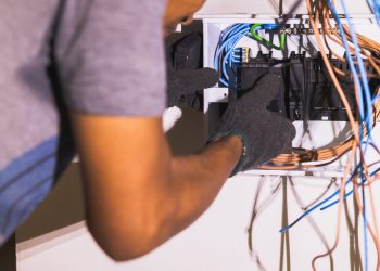 Electrician placing and adjusting circuit breakers