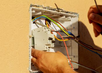 Panel with electrical equipment. An electrician installs circuit breakers. Switching devices with manual control are designed to turn on the disconnection of small load currents.